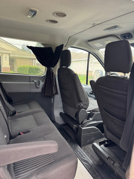 Spacious RV rental van interior with rear and front passenger seats, overhead lighting, and air vents. Curtains for privacy.