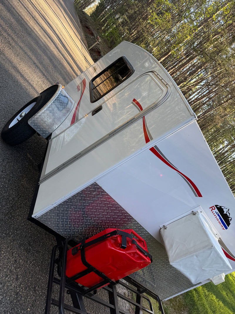 Compact Runaway teardrop camper, ideal for your next RV rental adventure, parked on an asphalt road with trees in background. — photo 2