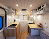 Step into this modern RV rental interior. A cozy camper van features a bed, compact kitchen, and smart storage with light wood accents.