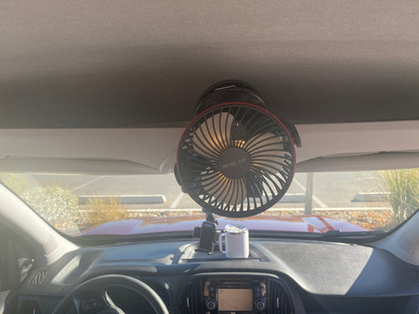 Portable fan mounted on rv rental ceiling, dashboard with phone holder & mug. Enhancing your journey comfort.