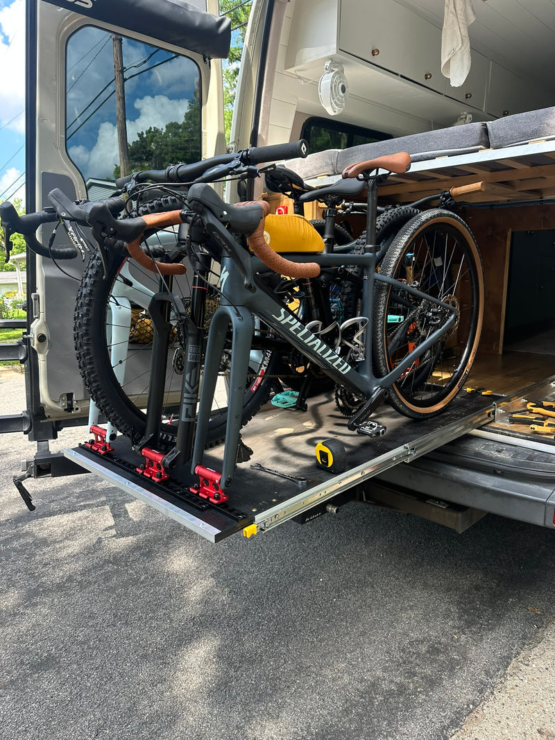 Rear view of an RV rental showing a sliding bike rack with two bicycles, including a Specialized, extended for access. — photo 5