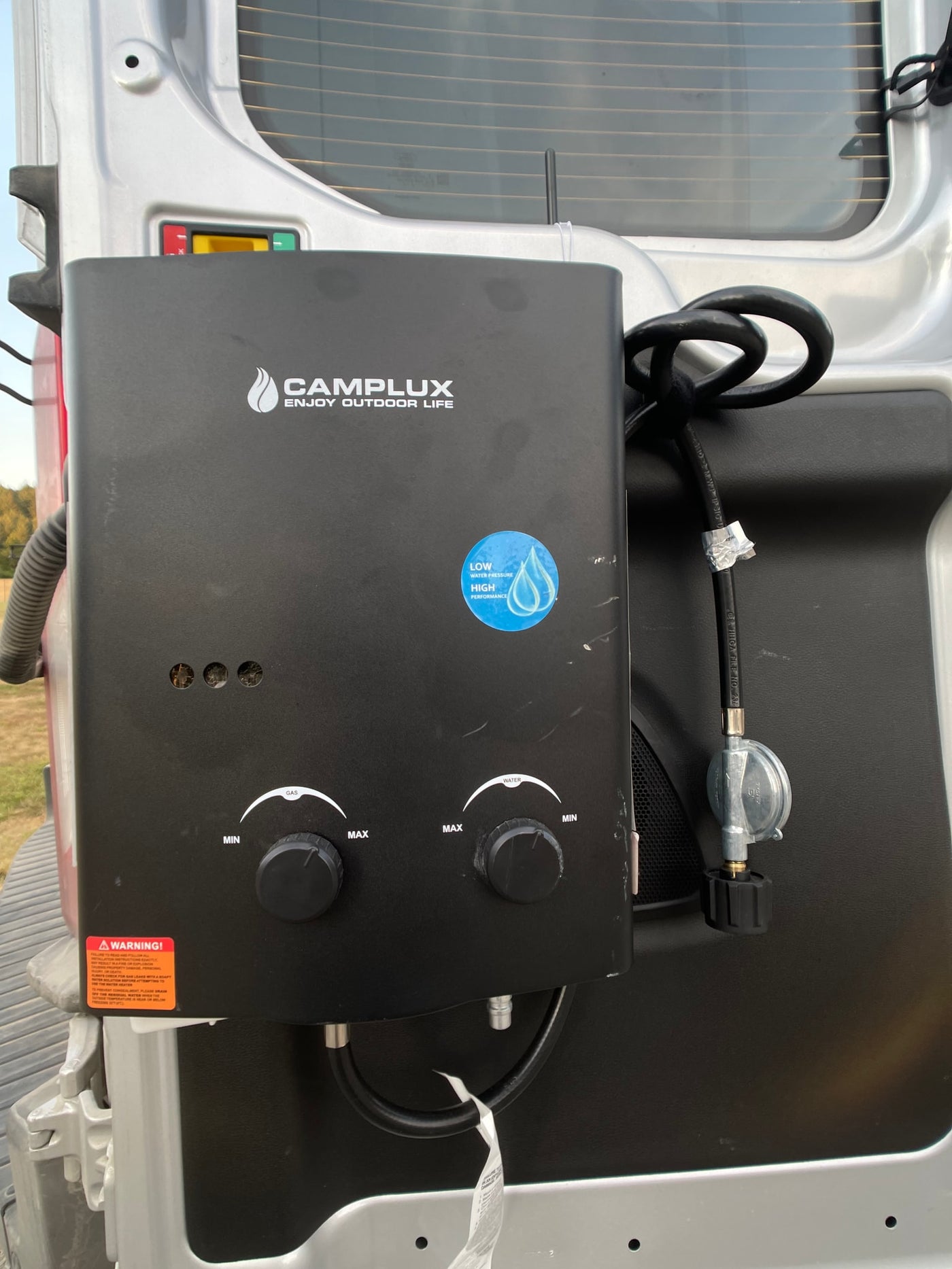 This photo shows a black Camplux portable water heater, useful for RV rental or camping, featuring gas and water controls. — photo 5