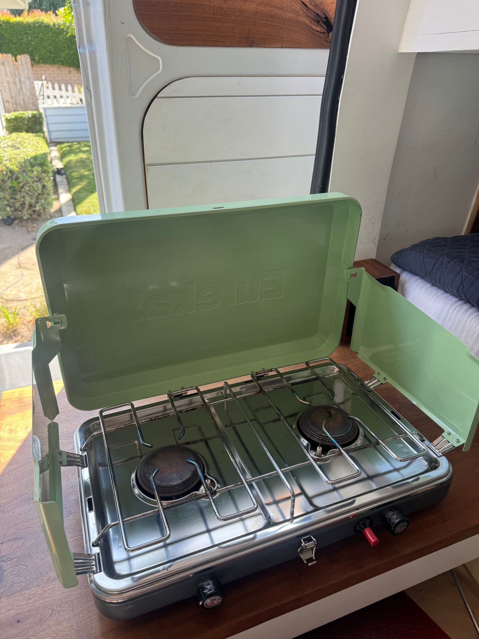Inside an RV rental, a compact two-burner camping stove is ready for easy meals on the go.