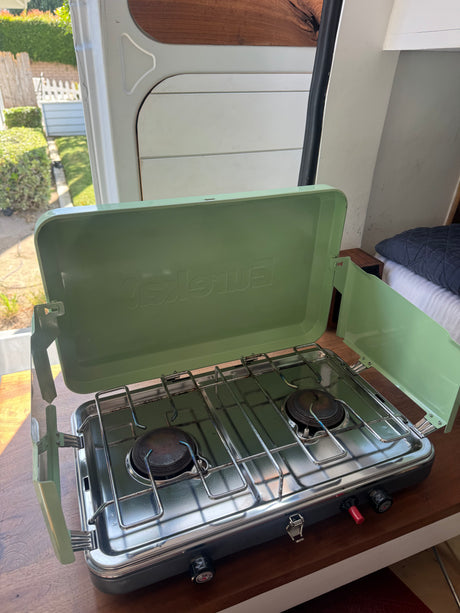 Inside an RV rental, a compact two-burner camping stove is ready for easy meals on the go.