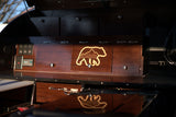 Detailed wooden cabinetry, a bear-mountain design, and an integrated power panel in an RV rental's interior.