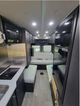 Spacious modern RV rental interior featuring kitchen, fridge, and cozy seating. Ideal for road trips.