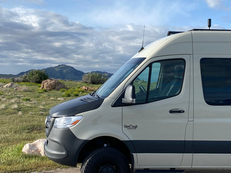 A rugged VanCraft camper van, ideal for RV rental adventures, parked in a scenic mountain landscape.