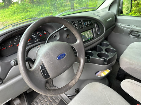 Driver's view in an RV rental van. Shows a worn Ford steering wheel, dashboard (273k miles), and infotainment screen.
