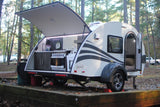 This compact teardrop camper, ideal for an RV rental, displays its open rear kitchen and open side door in a wooded campground.