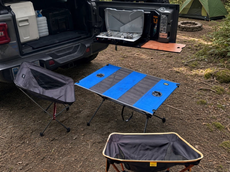  sits on a dirt forest road.|Adventure-ready grey Jeep Wrangler RV rental with a rooftop tent and cargo box — photo 5