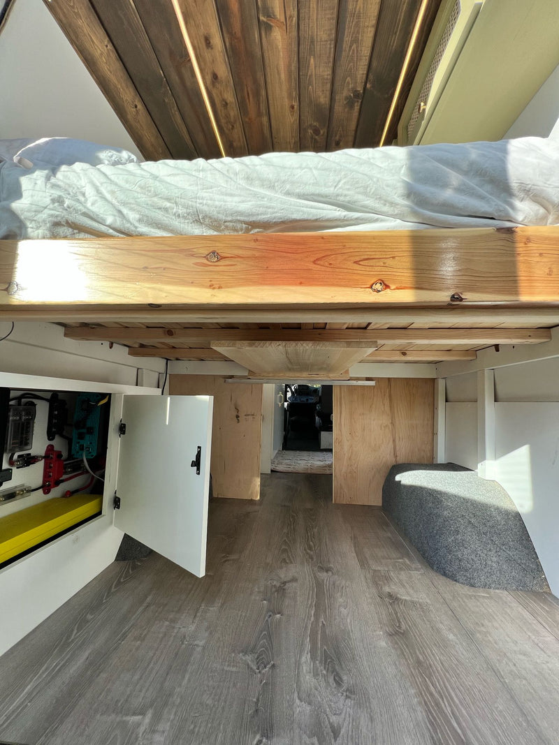 and an open fridge with outdoor nature views.|Custom RV rental interior featuring a wooden ceiling — photo 11