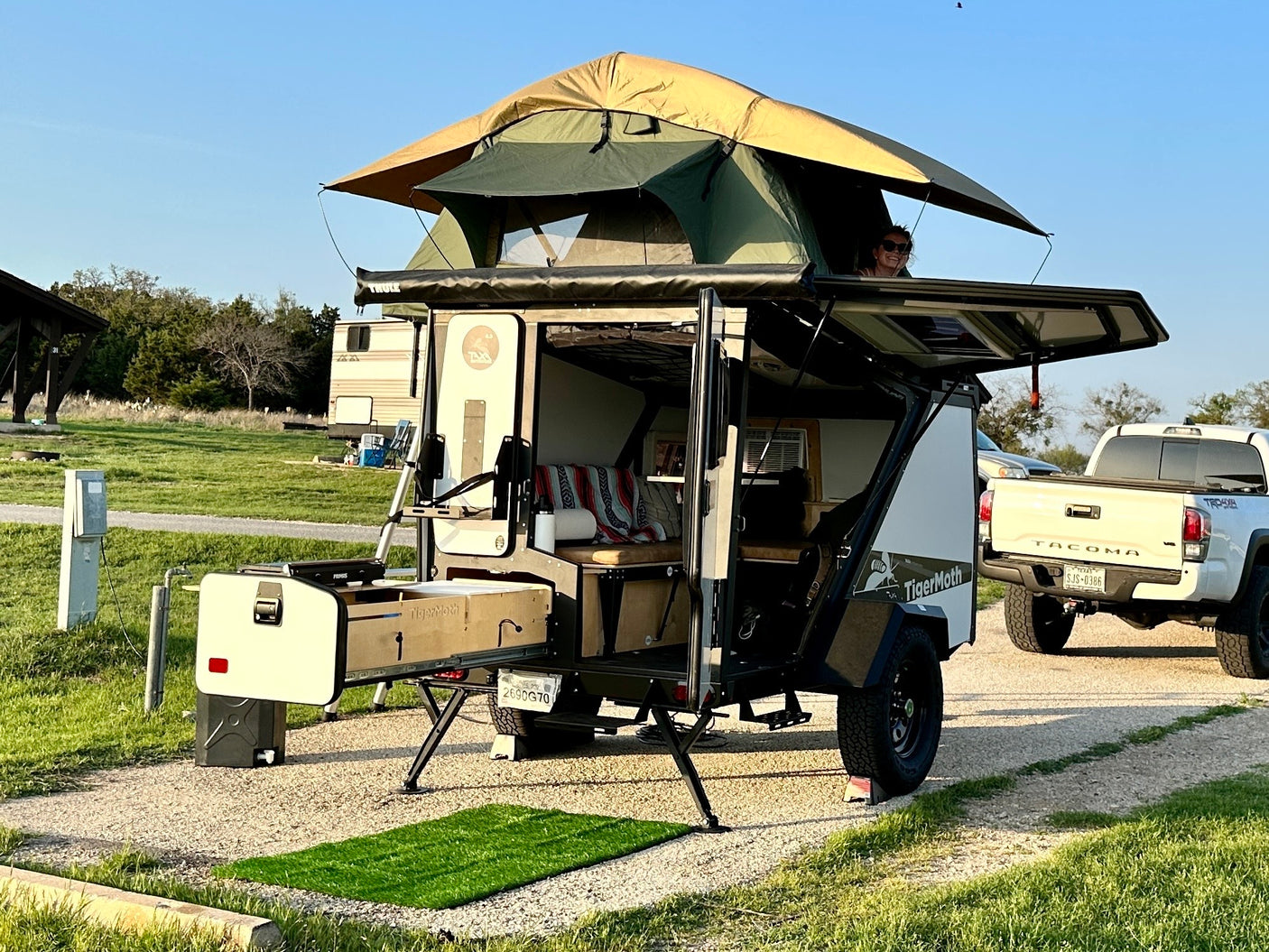 Enjoy adventure camping with this TigerMoth RV rental. Unique teardrop camper features a rooftop tent & outdoor kitchen.
