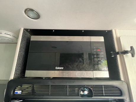 This rv rental features a built-in Galanz air fry microwave above a Norcold refrigerator.