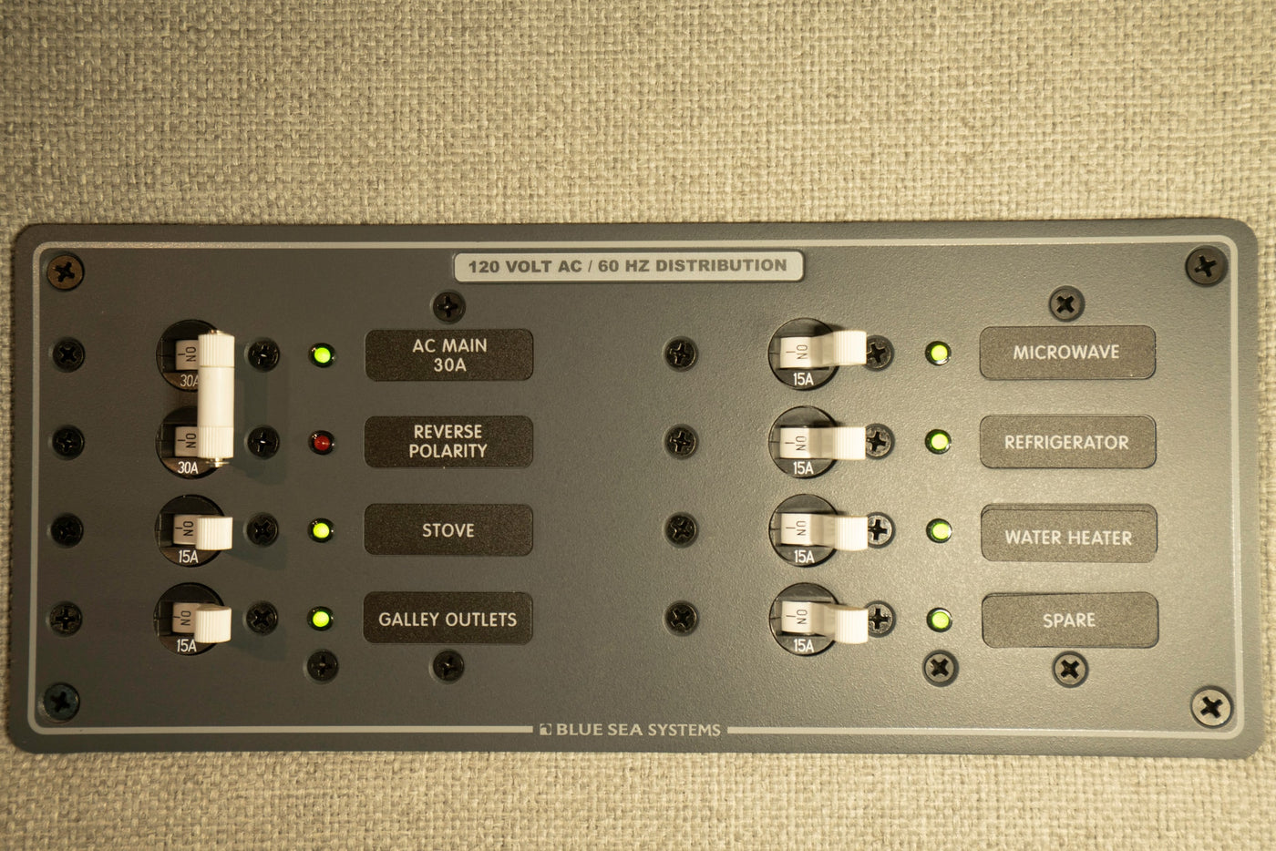 RV rental panel: 120V AC distribution with circuit breakers for microwave, refrigerator, stove, water heater, and galley outlets. — photo 12