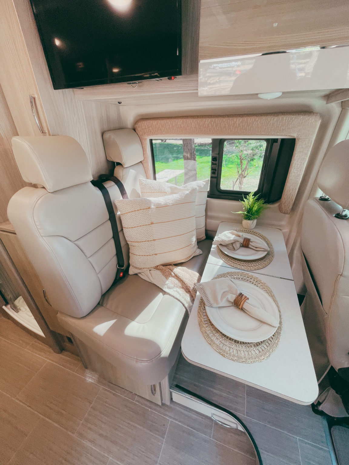  and modern amenities for a comfortable travel experience.|RV rental: Dark camper van with awning & raised pop-top. Outdoor setup: patterned rug — photo 3