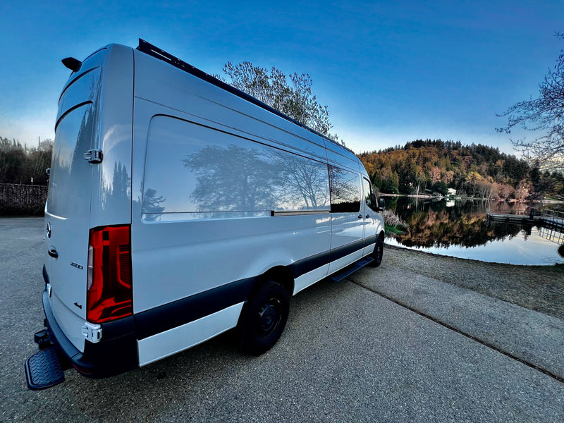 This white Mercedes-Benz Sprinter rv rental is perfectly parked by a calm lake, reflecting trees and sky. — photo 6