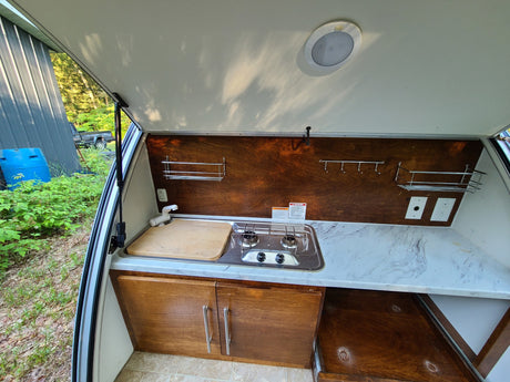  and scenic window views for comfortable travel.|A white teardrop camper with black stripes