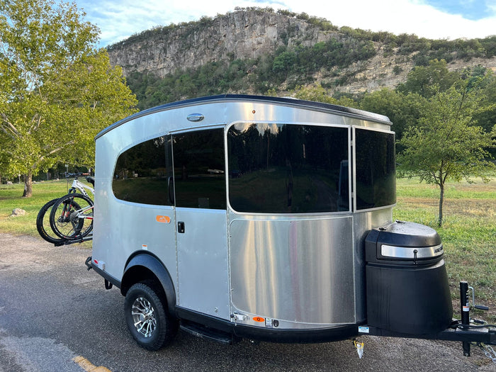  and a picnic table with food. A dog sits by the table.|RV rental interior features blue seating