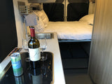 Ready for adventure! This RV rental offers a cozy bed, compact kitchen, wine, and sparkling water for a relaxing trip.