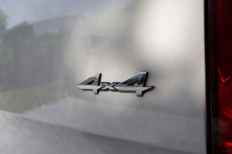 A chrome '4x4' emblem on a light gray RV rental's rear. — photo 13