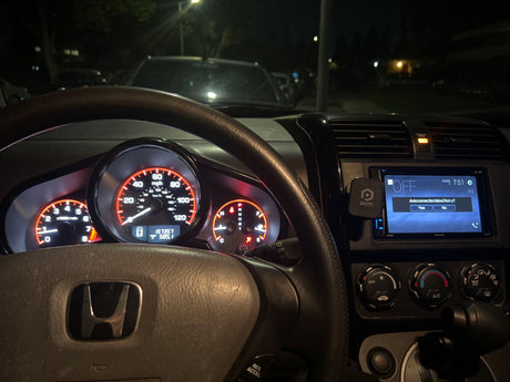 Illuminated Honda car dashboard at night with navigation screen showing a connection error. A compact ride, unlike an RV rental.