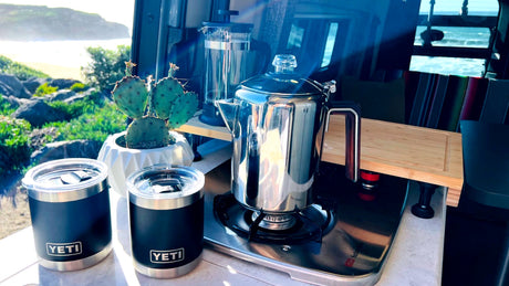 RV rental life: Beach views, coffee percolating on the stove, and a French press ready. Yeti mugs await!