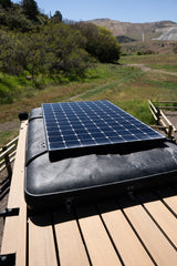 RV rental adventure: Solar panel on a rooftop tent, ideal for off-grid camping in a scenic, rugged landscape.