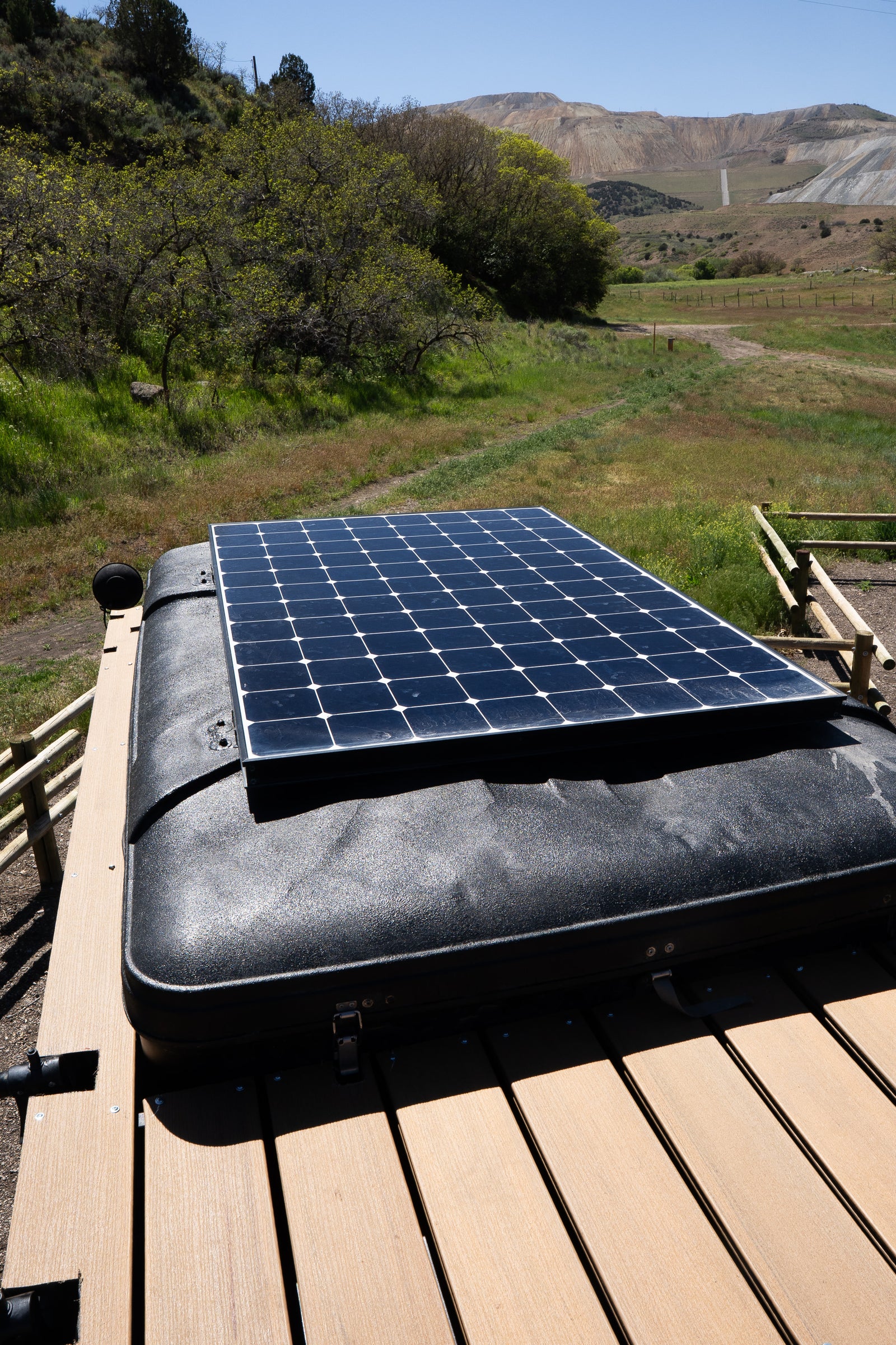 RV rental adventure: Solar panel on a rooftop tent, ideal for off-grid camping in a scenic, rugged landscape.