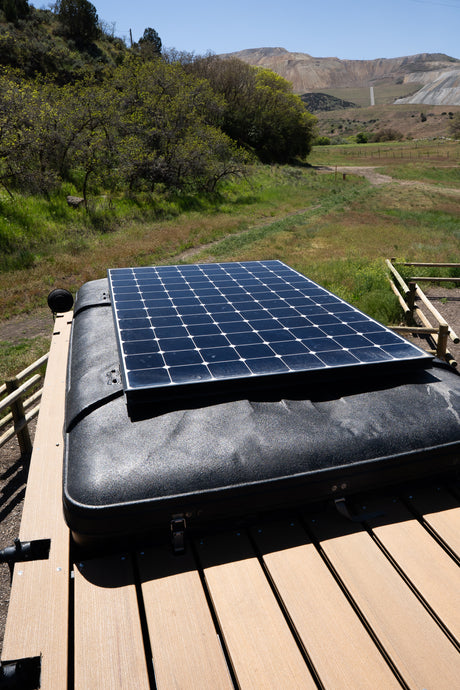 RV rental adventure: Solar panel on a rooftop tent, ideal for off-grid camping in a scenic, rugged landscape.