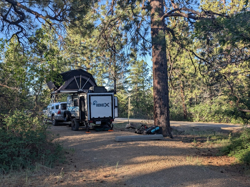  and chairs in a serene forest.|Compact IBEX rv rental with rooftop tent — photo 7