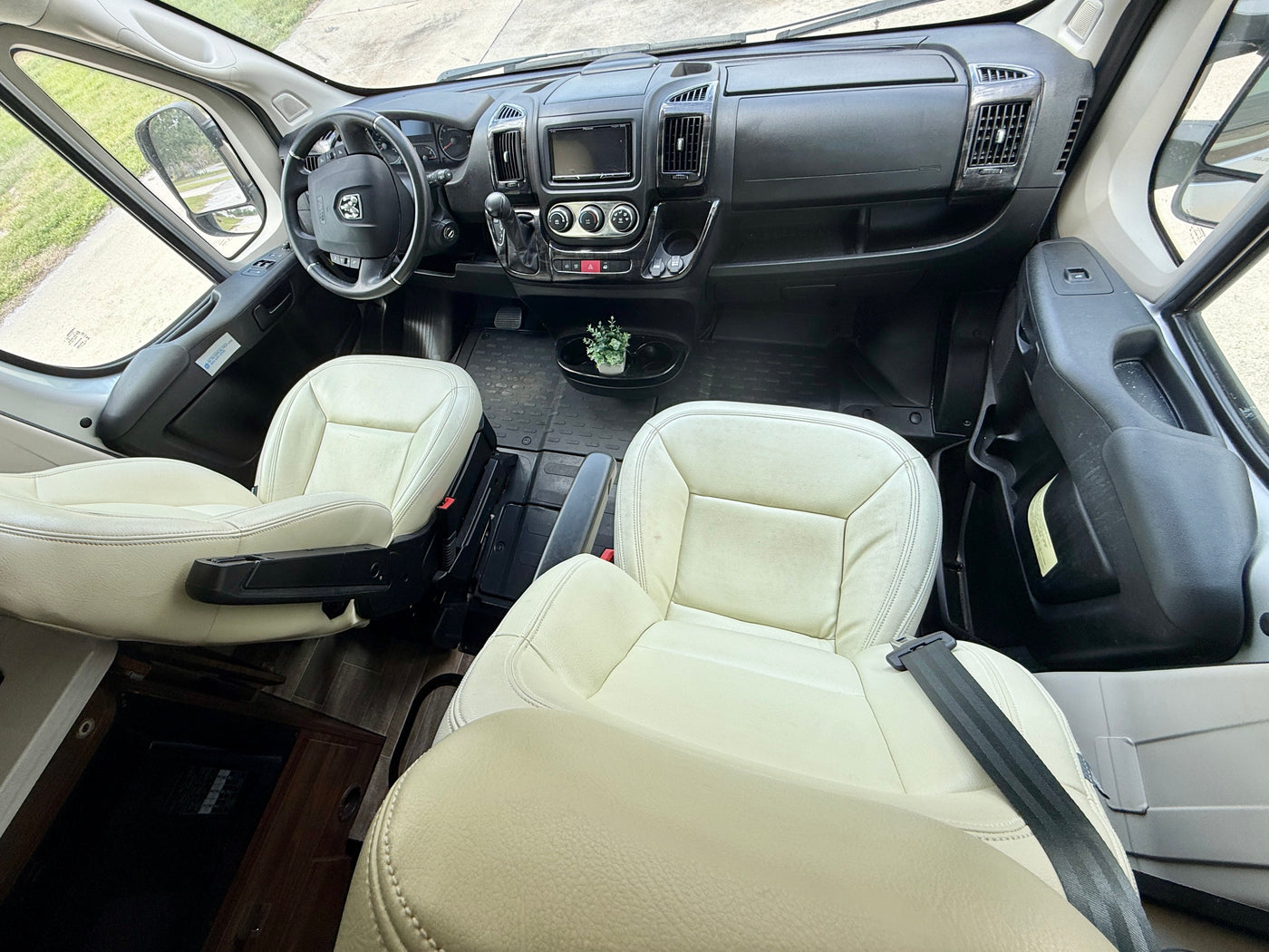 RV rental: Bright, clean camper van cockpit featuring cream seats, dashboard, and steering wheel, ready for adventure. — photo 11