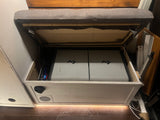 RV rental interior: open bench reveals two portable Dometic fridges & storage, enhancing compact living.