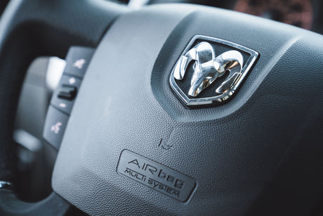 Close-up of a Ram steering wheel's logo and 'AIRBAG MULTI SYSTEM' text. Typical interior for a sturdy RV rental.