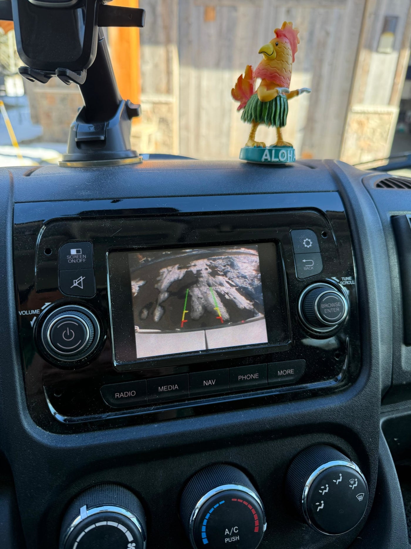 An RV rental dashboard displays an active backup camera view, a decorative hula rooster, and infotainment/climate controls. — photo 15