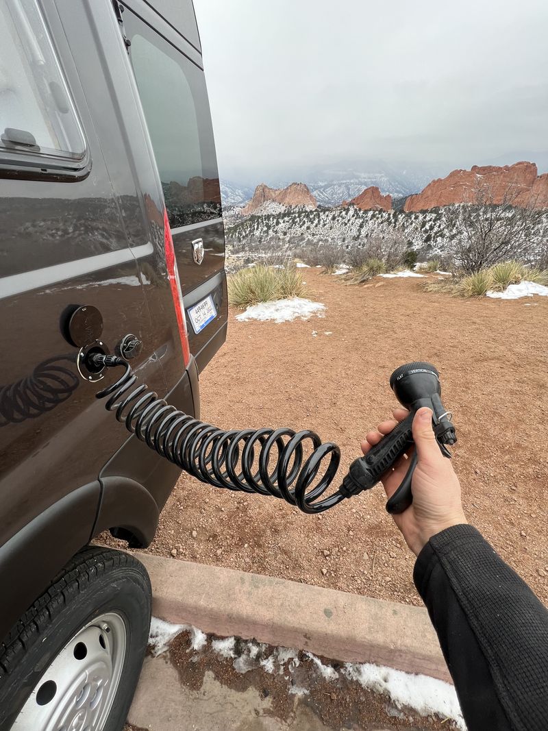  featuring a rear ladder and roof AC unit.|Outdoor shower from an RV rental van in snowy Garden of the Gods — photo 8