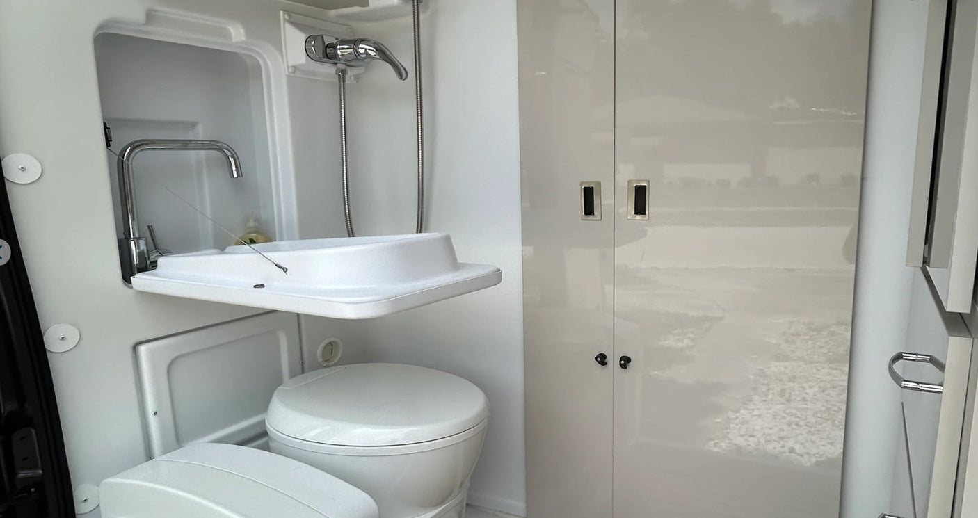  and a bed with gray linens.|RV rental interior: modern kitchen with sink