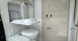  and a bed with gray linens.|RV rental interior: modern kitchen with sink