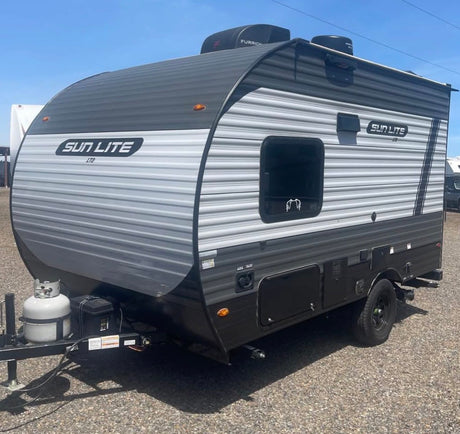  gray and black Sun Lite LTD travel trailer with a spare tire