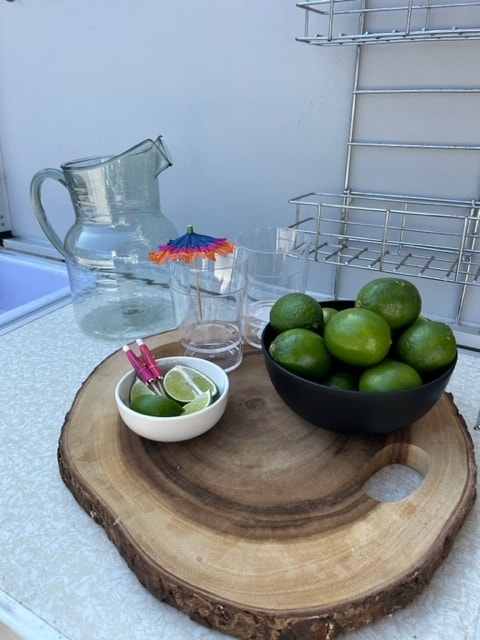 RV rental refresh: Limes, pitcher, and glasses arranged on a wooden serving board, perfect for drinks on your trip. — photo 11