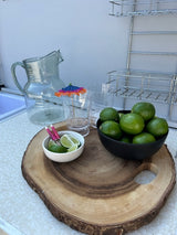 RV rental refresh: Limes, pitcher, and glasses arranged on a wooden serving board, perfect for drinks on your trip.