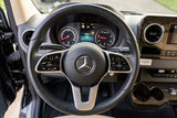 RV rental: Driver's perspective of a Mercedes-Benz interior, highlighting the modern steering wheel, dashboard, and controls.