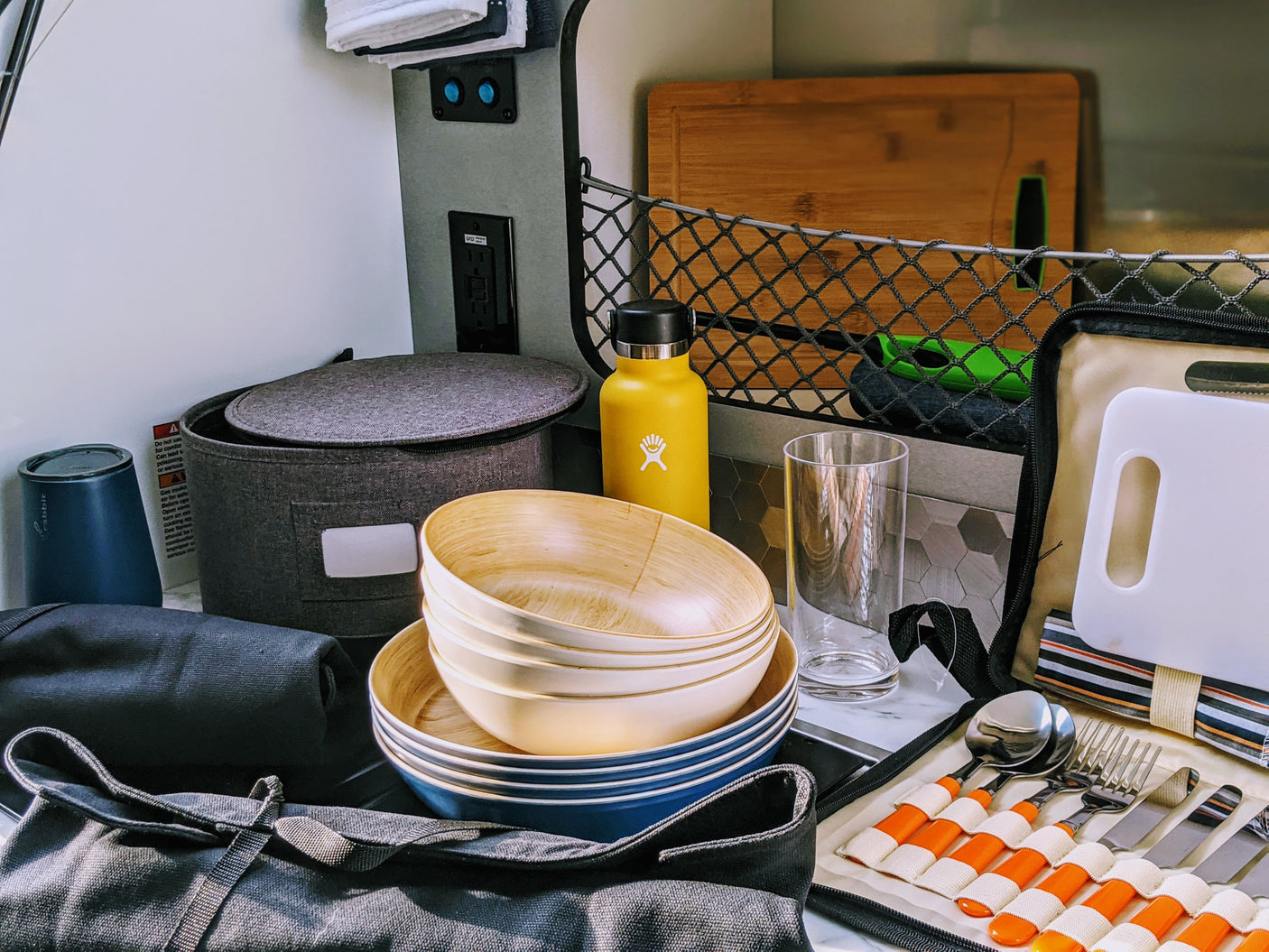 RV rental camp kitchen: Packed with bamboo bowls, Hydro Flask, cutlery, and cutting boards for your next outdoor adventure.