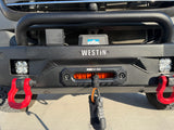 Front view of an RV rental's heavy-duty Westin bumper, featuring a Borne Off-Road winch, bright LED lights, and red tow hooks.