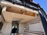 Open overhead wood storage cabinets in a modern RV rental camper van interior.