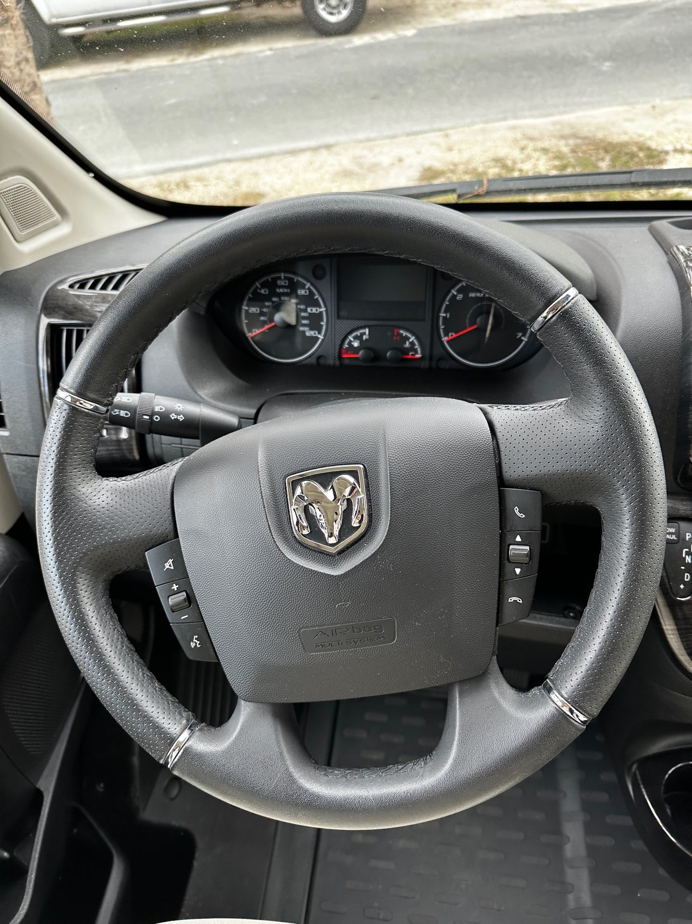 Inside an rv rental: Ram steering wheel with controls & dashboard gauges visible for the driver.