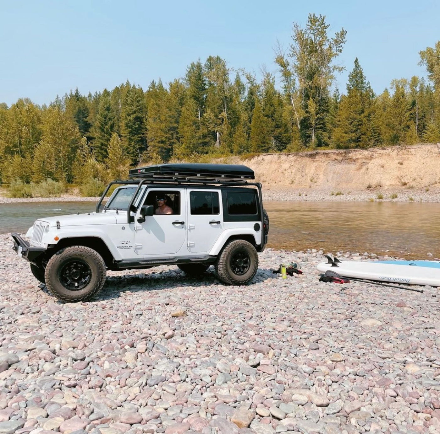  ideal for RV rental outdoor adventures. A driver and paddleboard are seen.|RV rental's cargo area neatly packed with camping gear: cooler — photo 4