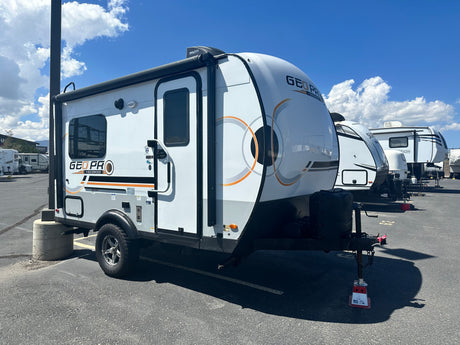 A compact, white and gray Geo Pro travel trailer (RV) on a paved lot, ready for your next rv rental adventure.
