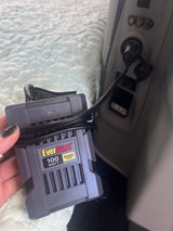 An EverStart 100W power inverter is plugged into an RV rental's outlet, offering portable power for devices.
