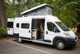 White Winnebago Solis camper van with pop-top extended and interior visible, ideal for rv rental adventures in nature.