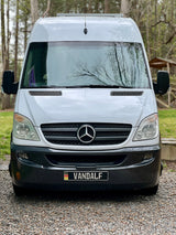 Front view of a white Mercedes Sprinter van with a custom "VANDALF" plate. Ideal for an RV rental, travel, or campervan adventure.